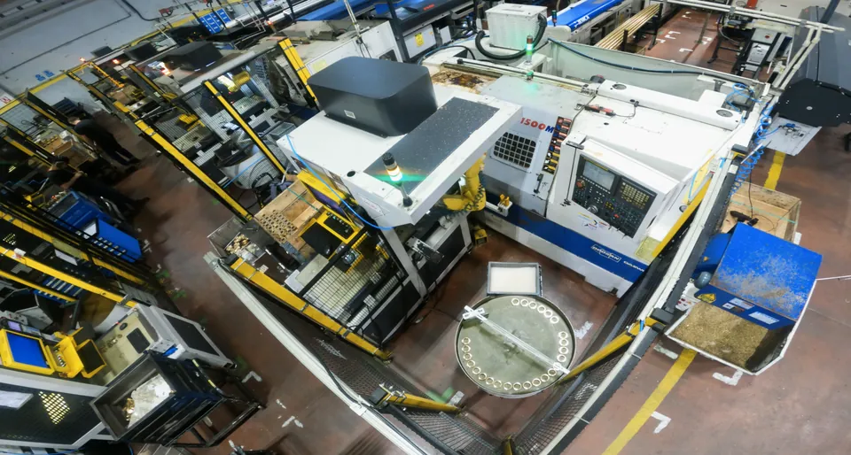 Raw parts on the conveyor, the robot at the lathe